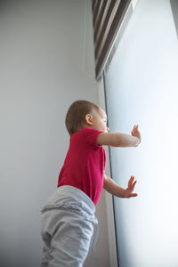 Baby standing against glass door. baby development concept