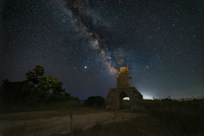 Panorama of an old tower during a starry night with the milky way