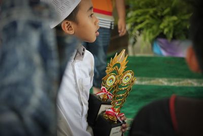 Midsection of boy holding hat