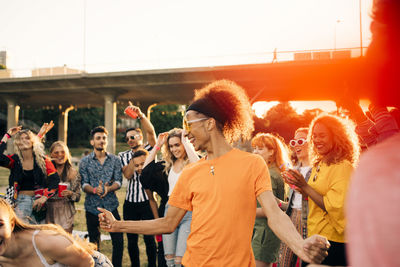 Man enjoying while dancing with friends in musical event during summer