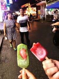 People holding ice cream cone at night