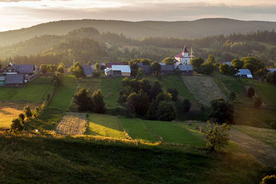 Scenic view of agricultural field against sky at sunset