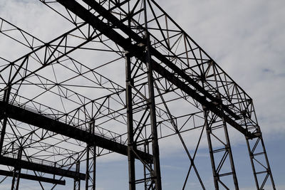 Low angle view of silhouette crane against sky