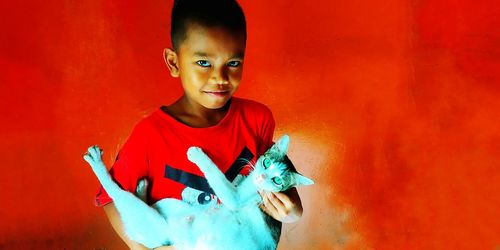 Portrait of boy holding red wall