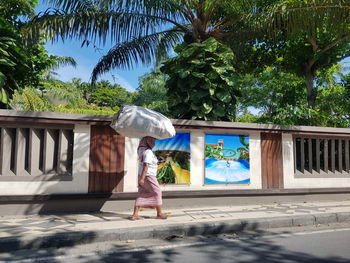 Full length of woman against blue sky