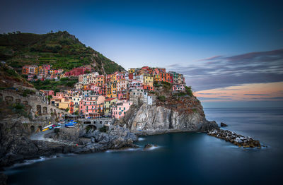 Scenic view of sea by buildings against sky