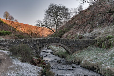 Arch bridge over river against sky