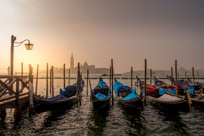 Gondolas moored at grand canal during sunset