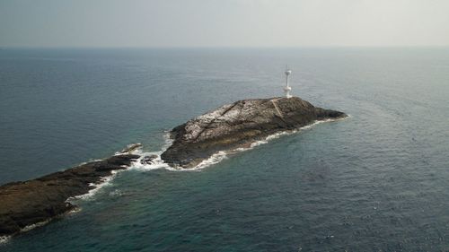 High angle view of rock in sea against sky