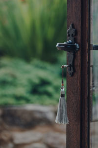 Key with a tassel key ring in the open door leading to the garden, selective focus.