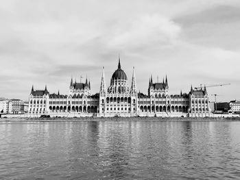 Government building in front of river against sky