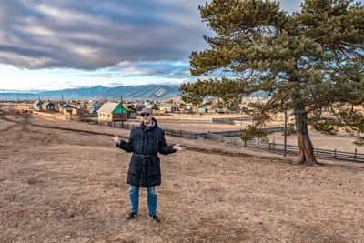 Rear view of man standing on ground against sky