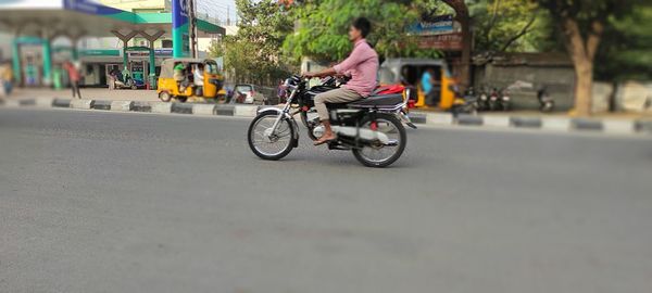 Man riding bicycle on road in city