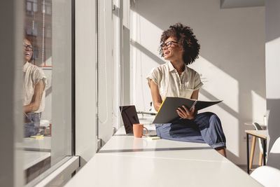 Businesswoman using laptop while sitting on table