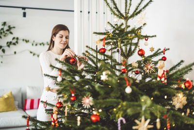 Portrait of woman holding christmas tree