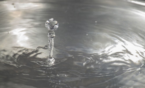 Close-up of drop falling on water in lake