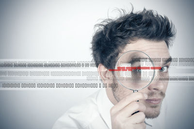 Close-up portrait of young man holding text against white background