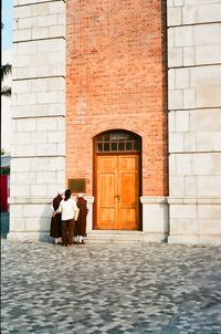 Rear view of people standing outside building