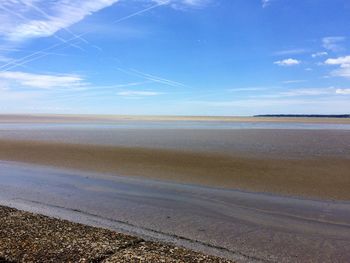 Scenic view of beach against blue sky