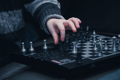 Cropped hand of child playing chess at home