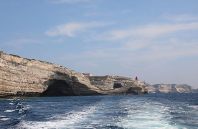 Rock formations by sea against sky