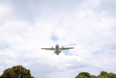 Low angle view of airplane flying against sky