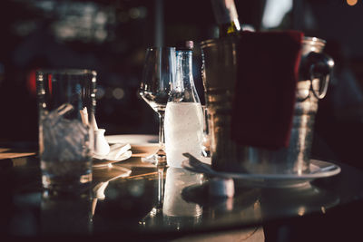 Still life of empty wine glasses and bottle of mineral water on table.