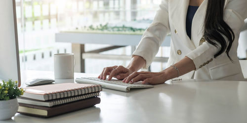 Midsection of woman using laptop on table