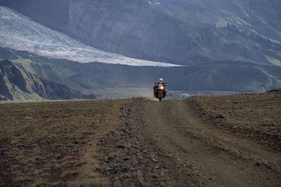 Man riding his adventure motorcycle on gravel road in iceland