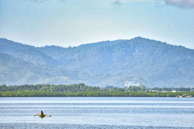 Scenic view of lake by mountains against sky