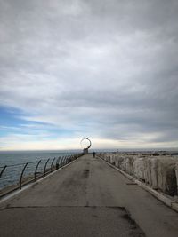 Road leading towards sea against sky