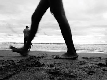 Silhouette men standing on beach against sky