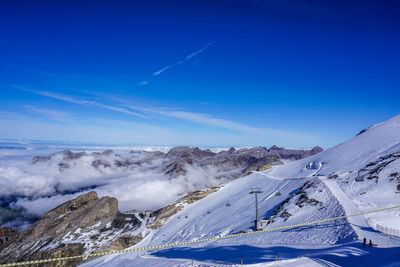 Scenic view of snowcapped mountains against blue sky