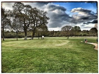 Scenic view of grassy field against sky