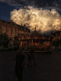 Buildings in city against cloudy sky