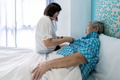 Woman lying on bed at home