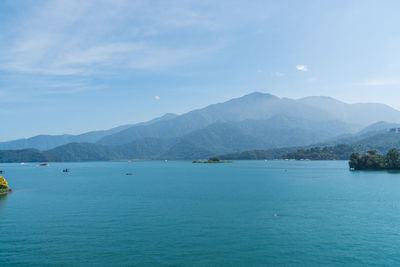 Scenic view of sea and mountains against sky