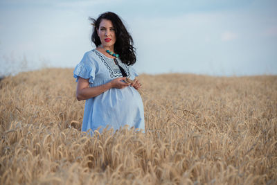 Woman standing on field against sky