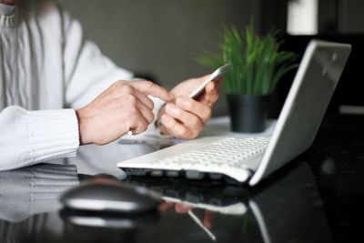 Midsection of man using mobile phone on table