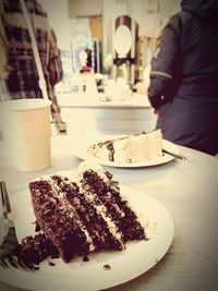 Close-up of hand holding ice cream on table