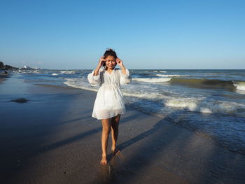 Full length of woman on beach against sky