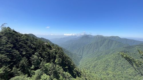 Scenic view of mountains against blue sky