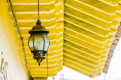 Low angle view of yellow lanterns hanging on ceiling