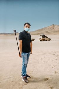 Full length of young man standing on desert go pro