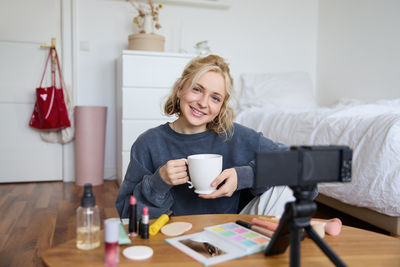 Portrait of young woman using mobile phone at home