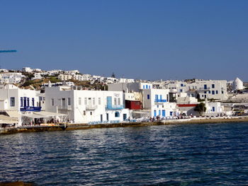 Houses in town against clear blue sky