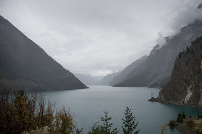 Scenic view of river and mountains against sky