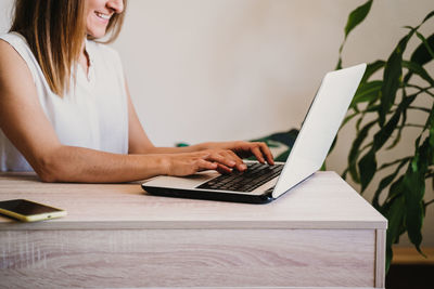 Woman using mobile phone while sitting on table