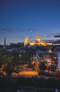 Illuminated cityscape against sky at night