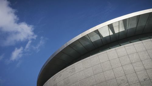 Low angle view of modern building against blue sky